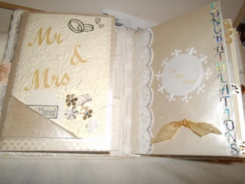 Wedding-1 A cream-coloured fabric wedding album with Latin phrases, featuring photo mats, pockets for keepsakes, and blog spots for personal notes, designed to preserve cherished memories in a timeless and functional way.