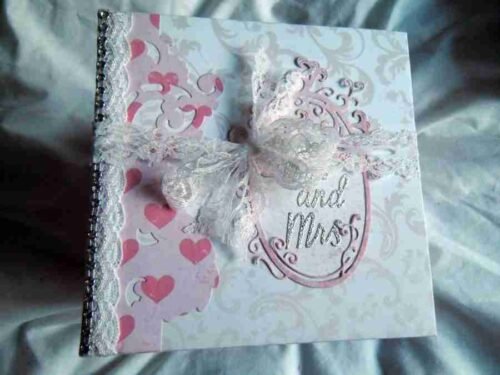 Wedding-4 is a photo album designed to hold up to 40 wedding photos. It features elegant photo mats, pockets for extra mementos, and spaces for personal notes to describe the memories and emotions behind each image.