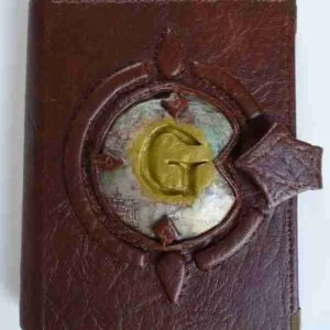 L.O.R-Sketchbook Compact brown faux leather sketchbook with stitched edges, magnetic closure, and high-quality pages. Features a raised "G" on a Middle-earth map. Durable and portable.