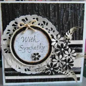 Sympathy Card-4 is a 13 cm x 13 cm square card in black and cream, designed to express condolences. It comes with a matching envelope. The card features a simple, elegant design intended to offer comfort and support during times of loss.