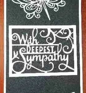 Sympathy Card-3 A tall sympathy card with a black textured background, featuring a row of white lace butterflies along the bottom and a larger lace butterfly at the top. The words "With Deepest Sympathy" are cut out in the centre.