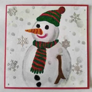 Snowman Christmas Card Handmade Christmas card featuring a Snowman with a glittered scarf and hat, surrounded by 3D snowflakes. The card is layered on red card stock and includes a matching red envelope. Inside is the verse, "May the miracle of Christmas fill your heart with wonder and joy."