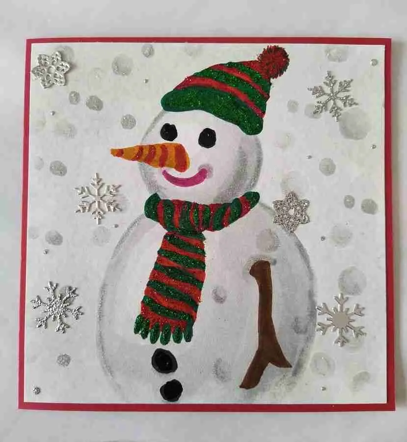 Snowman Christmas Card Handmade Christmas card featuring a Snowman with a glittered scarf and hat, surrounded by 3D snowflakes. The card is layered on red card stock and includes a matching red envelope. Inside is the verse, "May the miracle of Christmas fill your heart with wonder and joy."