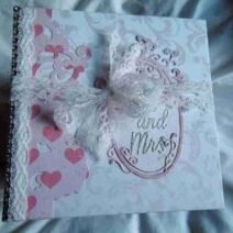 Wedding-4 is a photo album designed to hold up to 40 wedding photos. It features elegant photo mats, pockets for extra mementos, and spaces for personal notes to describe the memories and emotions behind each image.