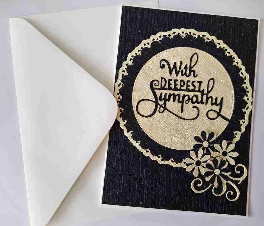 Sympathy-Card-6, a black textured sympathy card with layered beige and black circles, featuring the message "With Deepest Sympathy" in the bottom right. At the bottom right, there are cut-out daisy flowers in beige and black. The design conveys comfort and empathy during a time of loss.