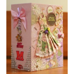 Chic-1 Birthday Photo Album with faux gemstones and elegant embellishments, holding up to 30 photos. It features interactive pages, including pockets, pull-outs, and a waterfall page. The album comes with a matching protective box for safe storage and can be personalized with the recipient's name, initials, or birthdate.