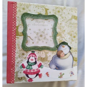 Christmas Cheer is a festive, interactive photo album designed to hold up to 30 photos. It includes pull-out pages, hidden pockets for keepsakes, and spaces for personal reflections, offering a creative way to preserve and share Christmas memories.