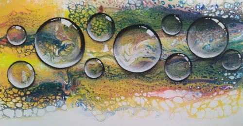 10 Breaths of Motion Close up of with ten glass-like orbs floating over a marbled, multicoloured background.