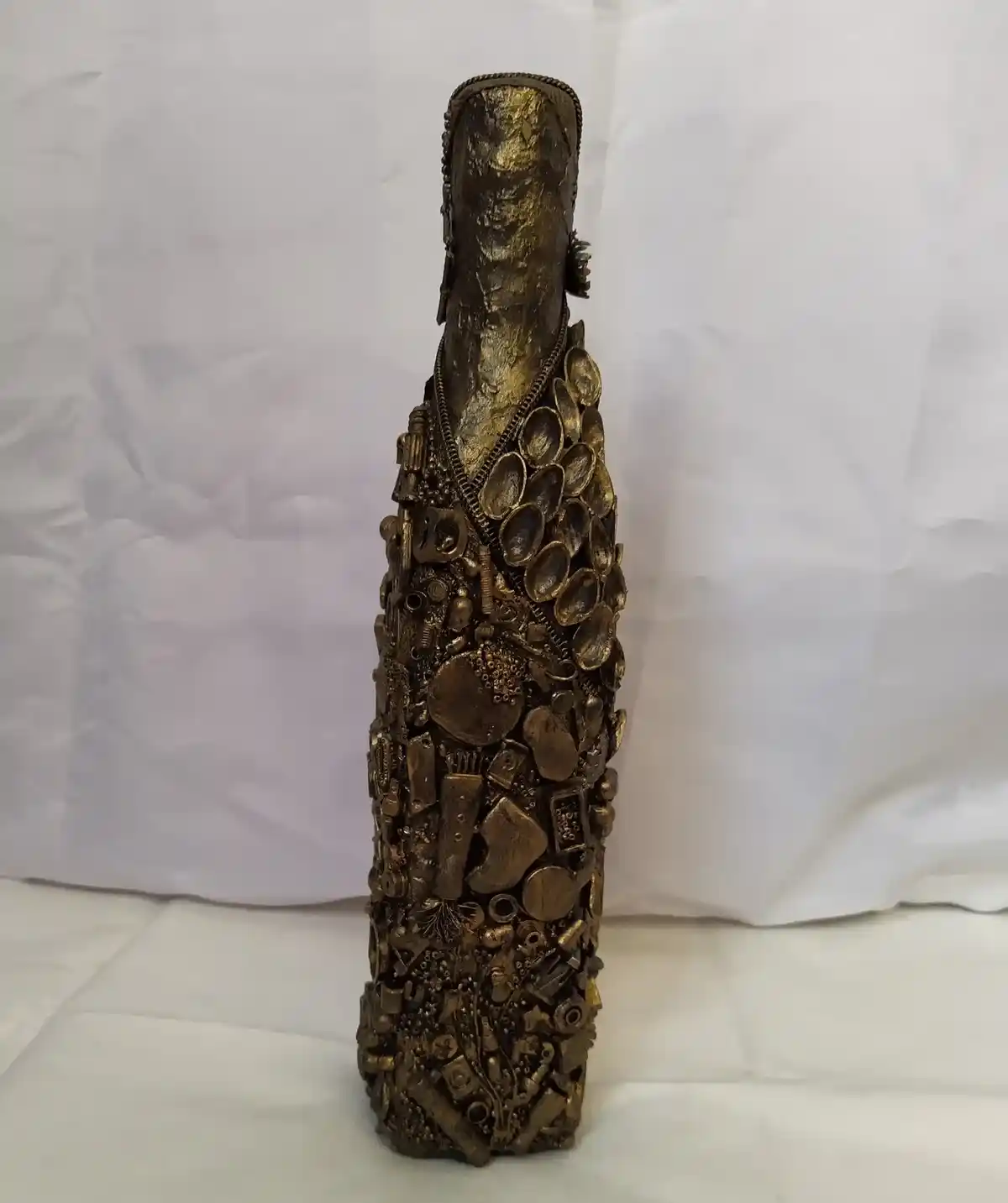 Bronze Bottle, Covered in recycled mixed media, all with a golden bronze finish.