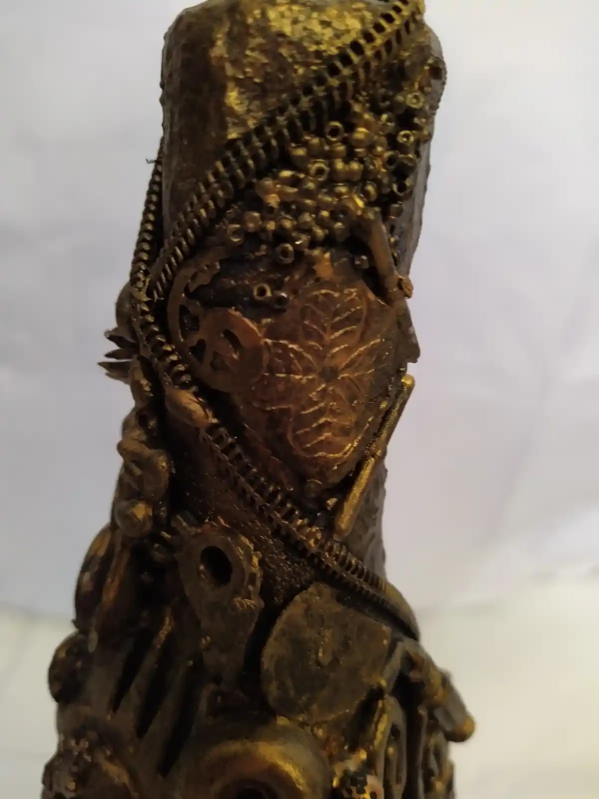 Bronze Bottle, close up shot of the neck of the bottle covered in recycled mixed media, all with a golden bronze finish.