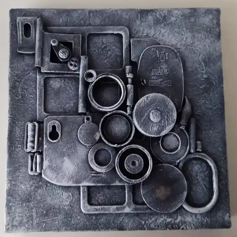 Metal assemblage artwork made from washers, bolts, and textured industrial pieces