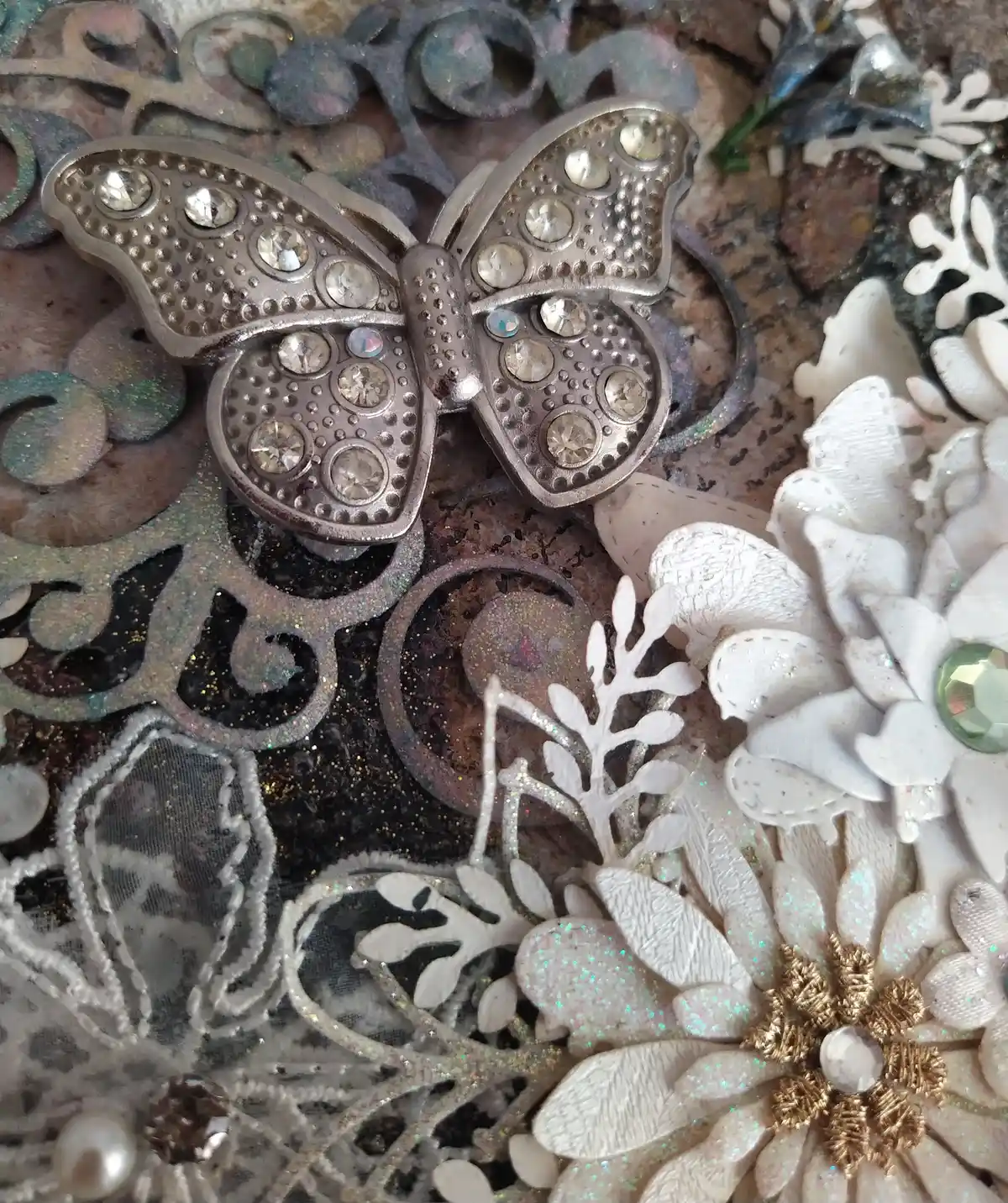 The Gentle Flutter, close up of mixed‑media artwork featuring a metallic butterfly, lace textures, and soft florals