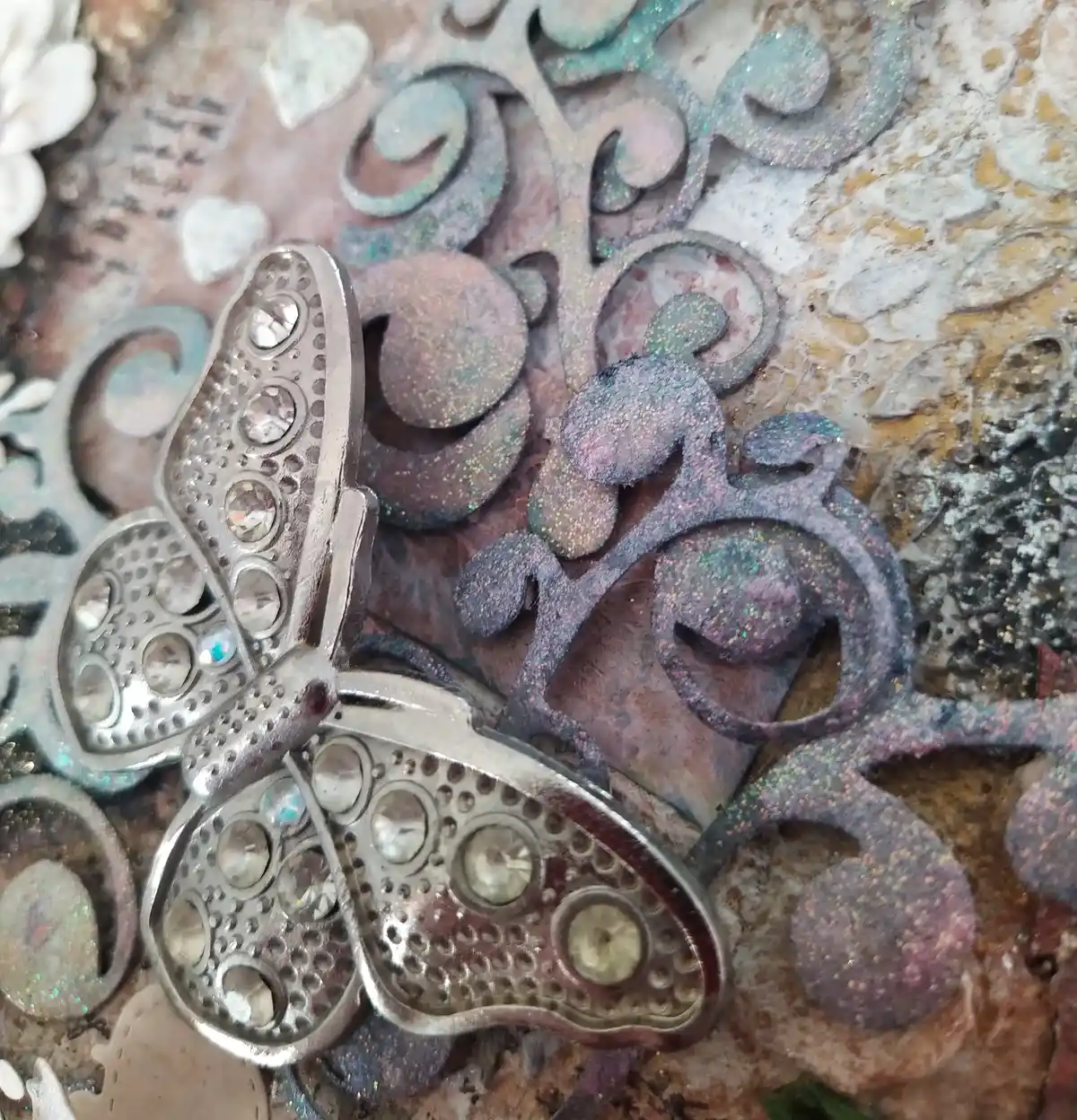 The Gentle Flutter, close up of mixed‑media artwork featuring a metallic butterfly, lace textures, and soft florals