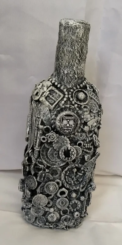 Bottle-O-Rum Bottle with a textured surface of recycled metals, plastics, and broken chains.