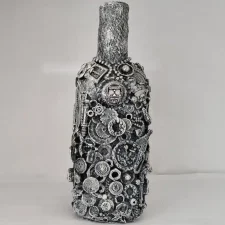 Bottle-1: Bottle-O-Rum, a mixed media bottle made covered with detritus of glass shards, small plastics and mixed metal pieces